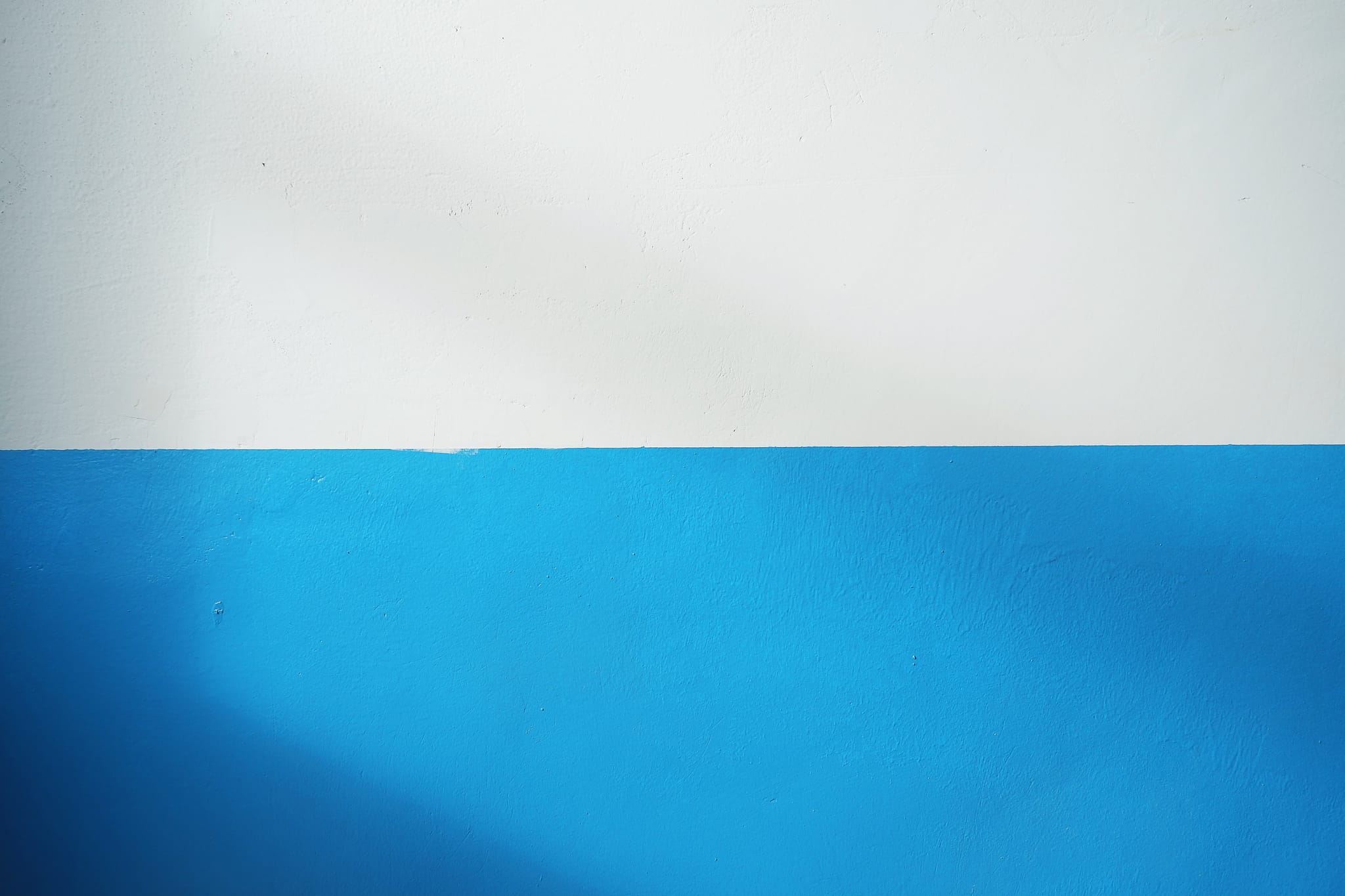 Eine Wand, zur Hälfte blau und zur anderen Hälfte weiß