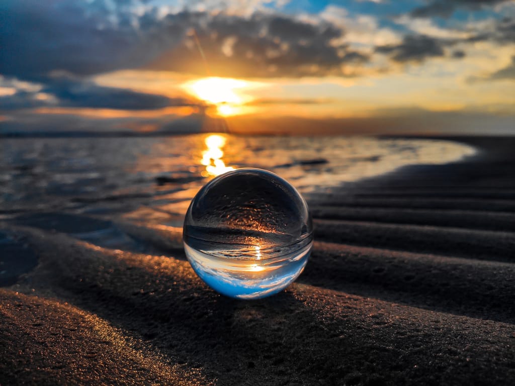 Glaskugel am Strand mit Blick aufs Meer